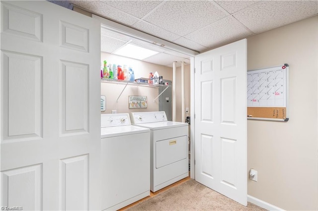 clothes washing area featuring laundry area, light colored carpet, baseboards, and separate washer and dryer