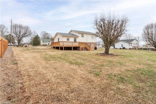 back of house featuring a yard, fence, a wooden deck, and stairs