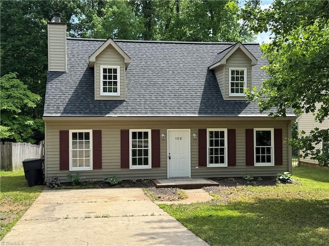 cape cod house featuring fence, a chimney, roof with shingles, and a front lawn