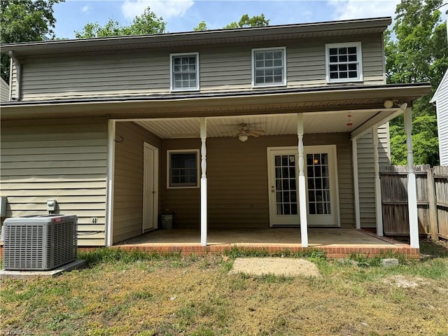back of house featuring fence, central AC, a patio area, a lawn, and a ceiling fan
