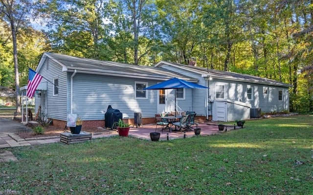 rear view of house with a patio, central AC unit, and a lawn