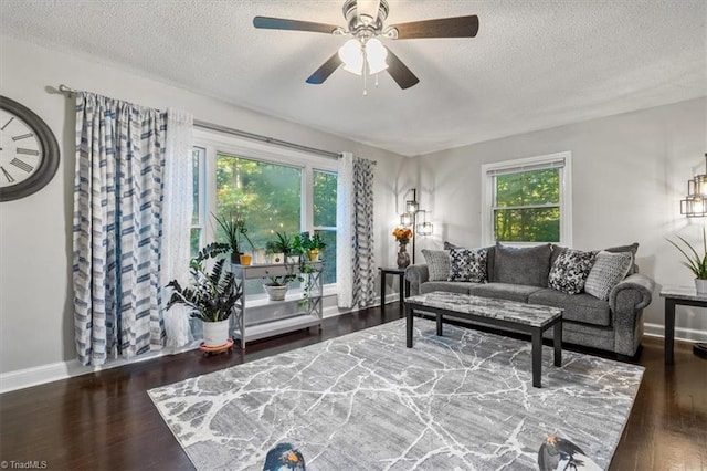 living room with a textured ceiling, ceiling fan, and dark hardwood / wood-style flooring