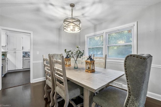 dining space with a notable chandelier and dark hardwood / wood-style flooring