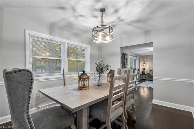 dining area with dark hardwood / wood-style floors and a textured ceiling