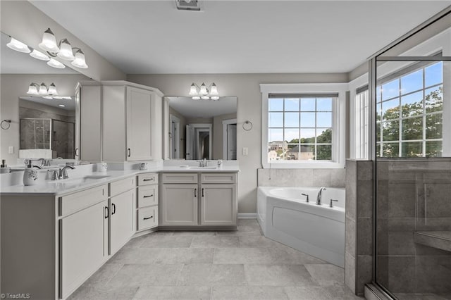 8004 Hacker Dr, Stokesdale, NC 27357 - bathroom featuring a chandelier, a bath, double vanity, a stall shower, and baseboards