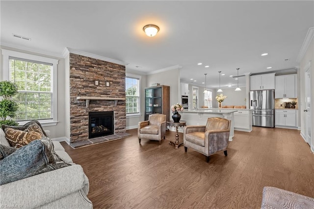 8004 Hacker Dr, Stokesdale, NC 27357 - living area featuring crown molding, wood finished floors, healthy amount of natural light, a fireplace, and baseboards