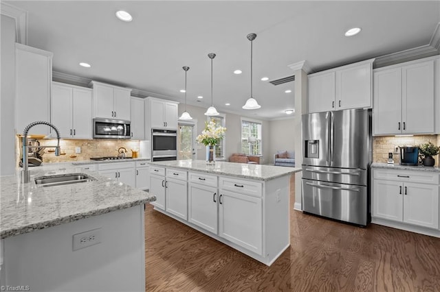 8004 Hacker Dr, Stokesdale, NC 27357 - kitchen with stainless steel appliances, a sink, a kitchen island, dark wood finished floors, and decorative backsplash