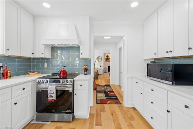 kitchen featuring white cabinets, custom range hood, tasteful backsplash, and electric stove