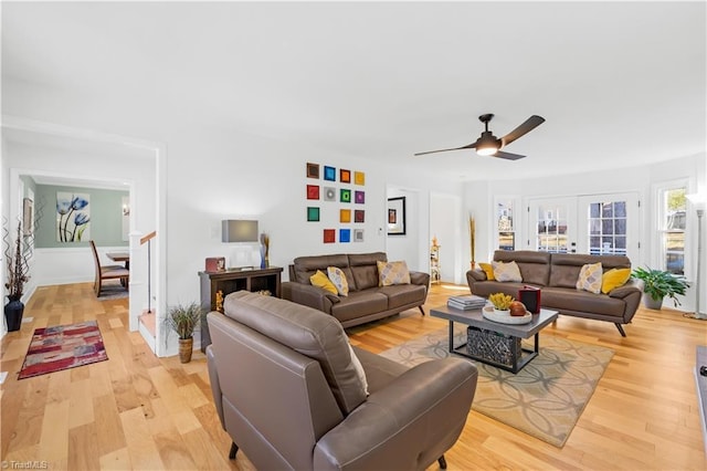 living room with light hardwood / wood-style flooring, ceiling fan, and french doors