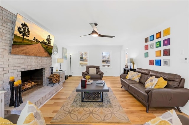 living room with light hardwood / wood-style floors, ceiling fan, and a fireplace