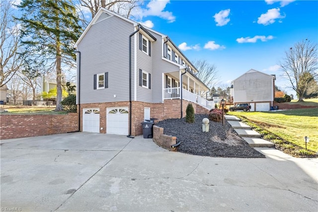 view of property exterior with a garage, covered porch, and a lawn