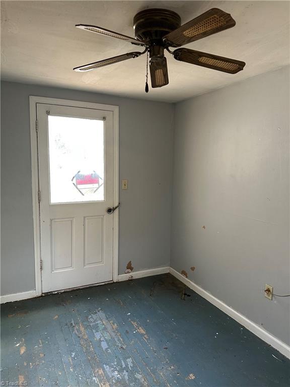 interior space with hardwood / wood-style flooring, baseboards, and a ceiling fan