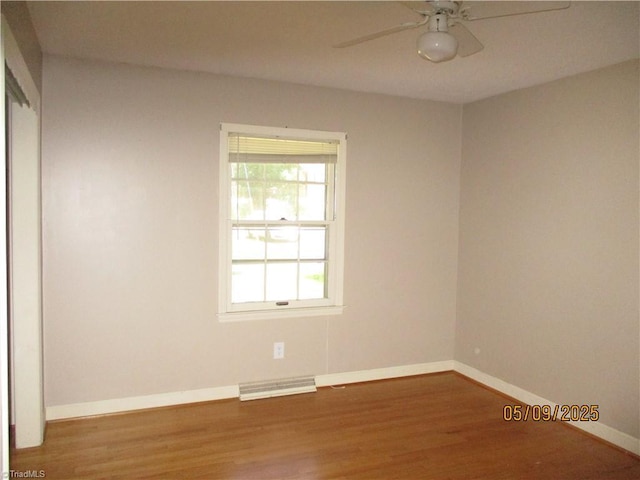 spare room featuring ceiling fan, wood finished floors, and baseboards