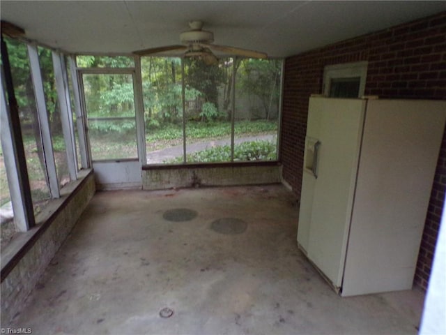 unfurnished sunroom featuring ceiling fan