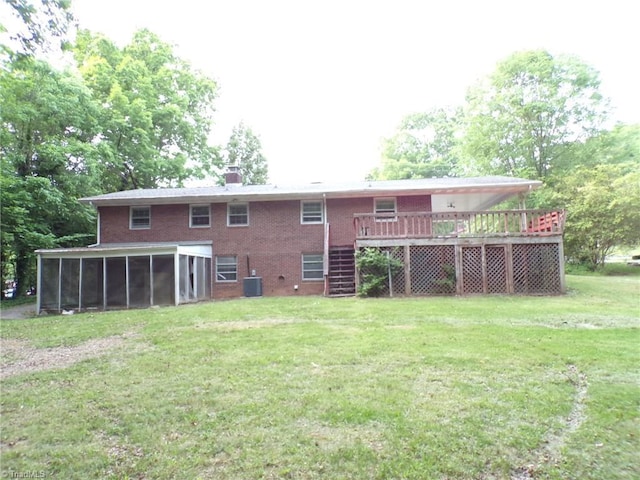 rear view of house with stairway, brick siding, a wooden deck, a yard, and a sunroom