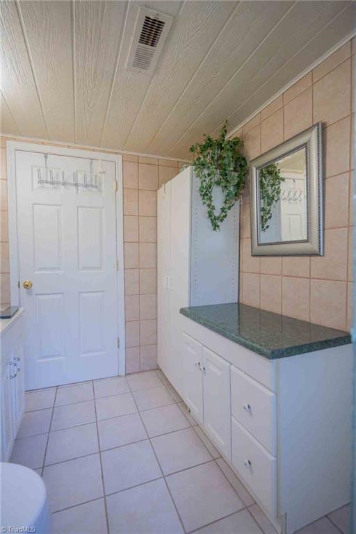 196 Watson Ln, Lexington, NC 27292 - bathroom with tile patterned floors, tile walls, wood ceiling, and vanity