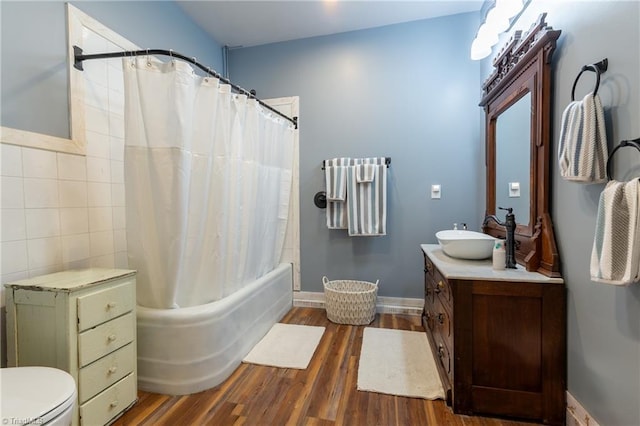 full bathroom with shower / tub combo with curtain, vanity, hardwood / wood-style flooring, tile walls, and toilet