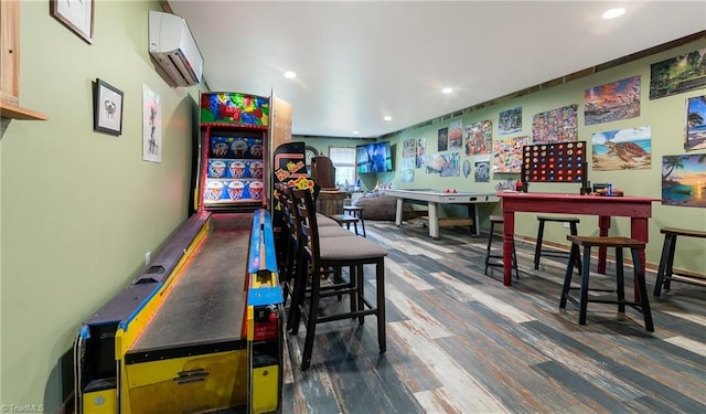 playroom with an AC wall unit and hardwood / wood-style flooring