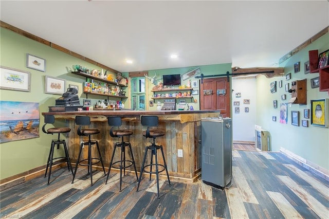 bar featuring dark hardwood / wood-style floors and a barn door