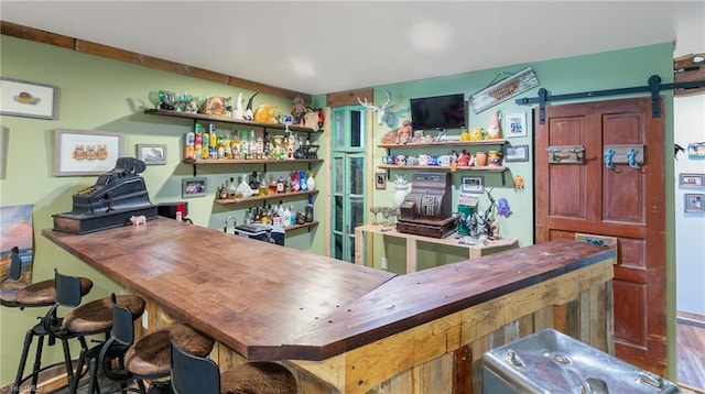 bar featuring butcher block countertops and a barn door