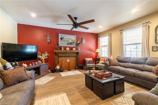 living room with light hardwood / wood-style flooring and ceiling fan