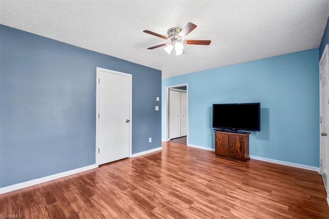1115 Wachovia St, Winston-Salem, NC 27101 - unfurnished living room featuring a ceiling fan, wood finished floors, a textured ceiling, and baseboards