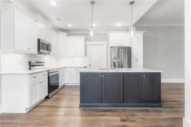 7028 Westfield Village Cir, Summerfield, NC 27358 - kitchen featuring appliances with stainless steel finishes, ornamental molding, white cabinets, a kitchen island with sink, and decorative backsplash
