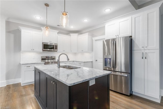 7028 Westfield Village Cir, Summerfield, NC 27358 - kitchen featuring appliances with stainless steel finishes, white cabinetry, crown molding, light wood finished floors, and backsplash