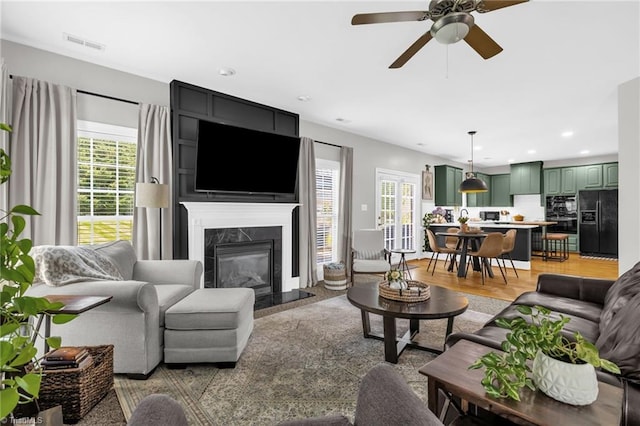 217 Oakmont Park Ct, Kernersville, NC 27284 - living area featuring a high end fireplace, a ceiling fan, recessed lighting, and light wood-type flooring