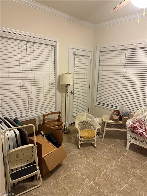 sitting room featuring tile patterned flooring, ceiling fan, and ornamental molding