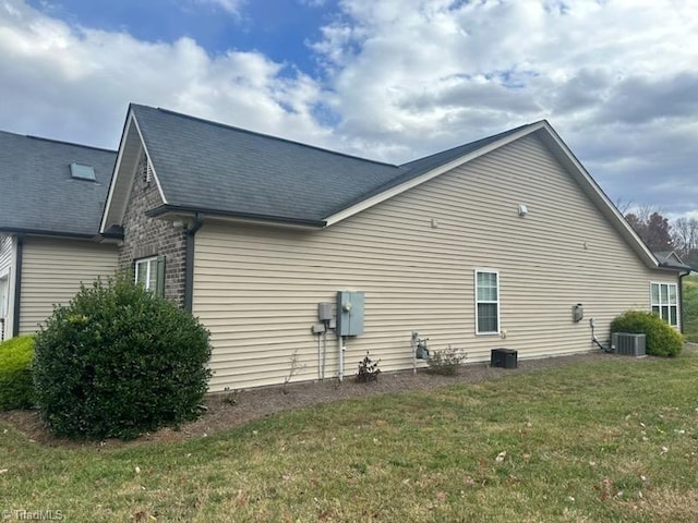 view of side of home with a yard and cooling unit