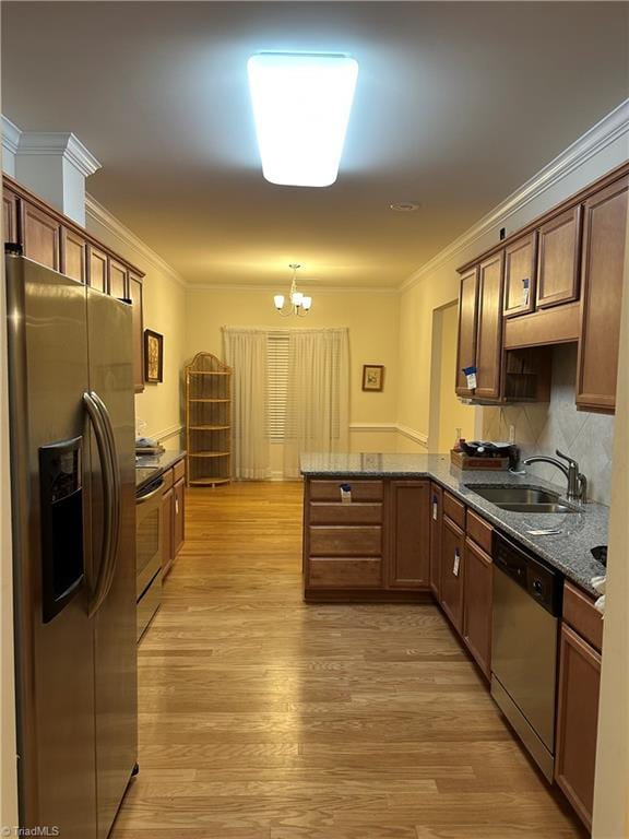 kitchen featuring sink, light hardwood / wood-style flooring, a notable chandelier, kitchen peninsula, and stainless steel appliances