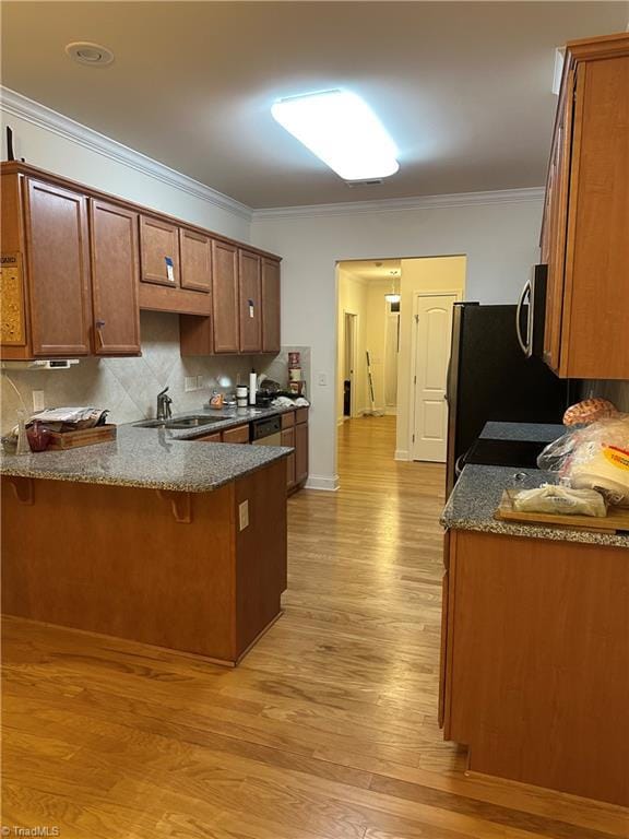 kitchen featuring kitchen peninsula, decorative backsplash, a breakfast bar area, and sink