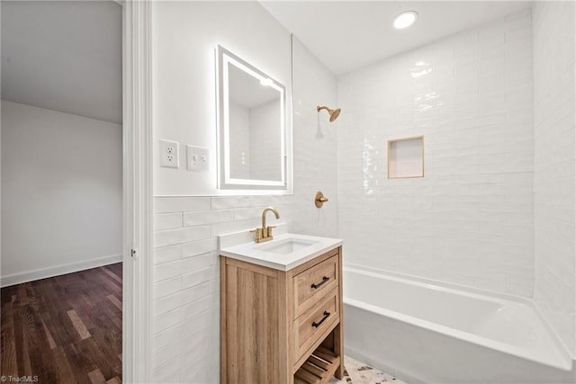 bathroom with tile walls, vanity, shower / bathtub combination, and hardwood / wood-style flooring