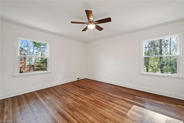 unfurnished room with a healthy amount of sunlight, dark hardwood / wood-style flooring, and ornamental molding