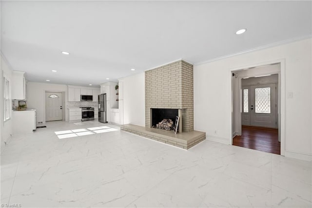 unfurnished living room with ornamental molding and a brick fireplace