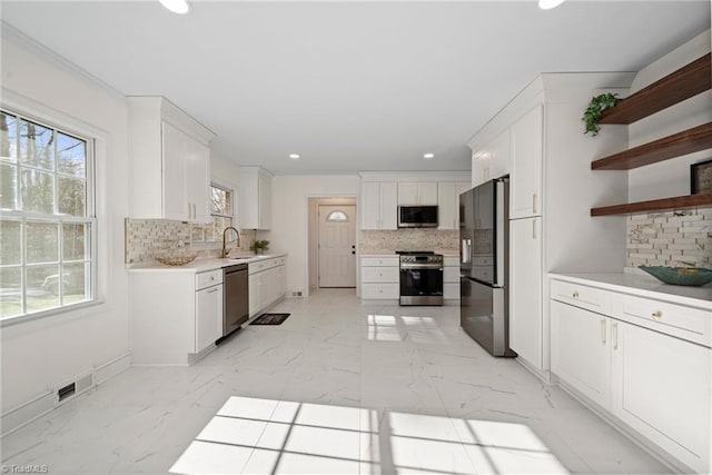 kitchen featuring white cabinets, sink, stainless steel appliances, and tasteful backsplash