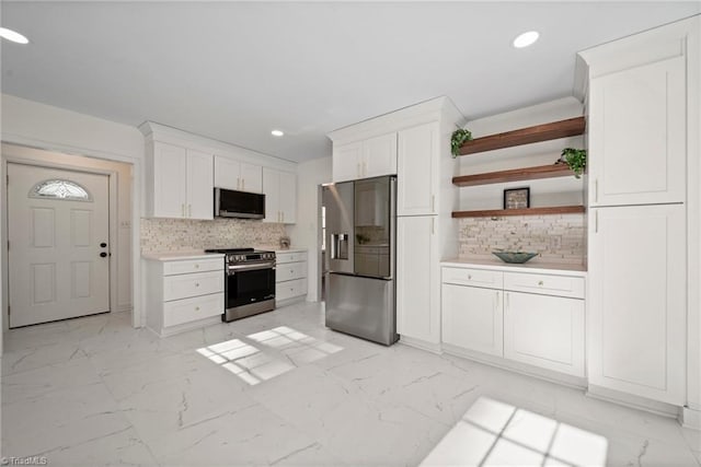 kitchen with white cabinets, stainless steel appliances, and tasteful backsplash