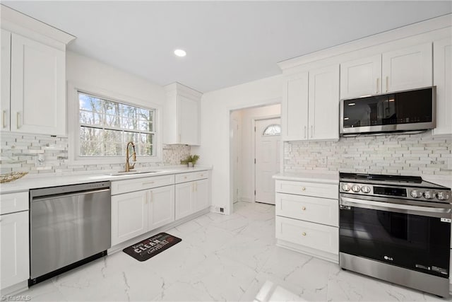 kitchen featuring white cabinets, sink, stainless steel appliances, and tasteful backsplash