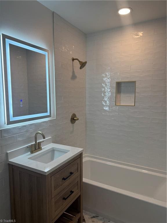 bathroom featuring vanity, tile walls, tiled shower / bath combo, and tasteful backsplash