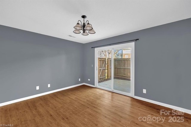 20 Dillingham Pl, Greensboro, NC 27455 - empty room with a chandelier, baseboards, and wood finished floors