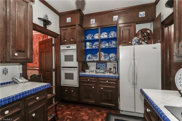 kitchen featuring tile countertops, white appliances, and dark brown cabinets