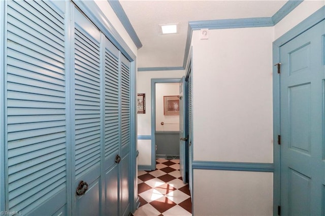 corridor with ornamental molding and tile patterned floors