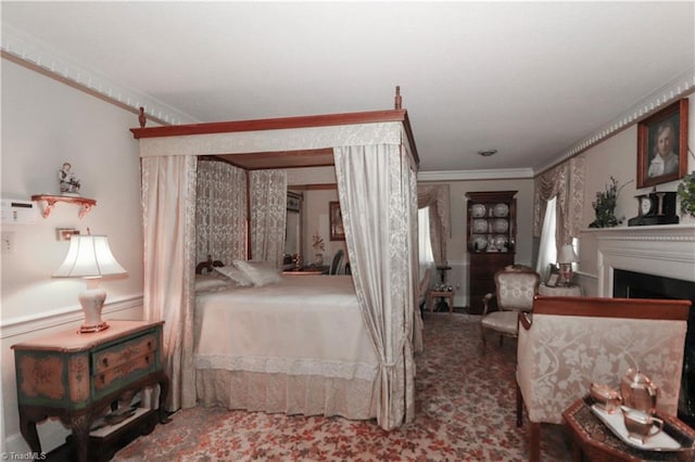 bedroom featuring a fireplace, crown molding, and carpet flooring