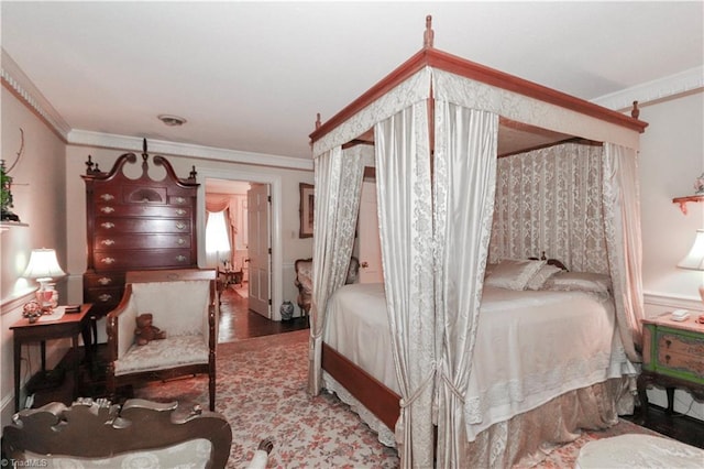 bedroom with wood finished floors and crown molding