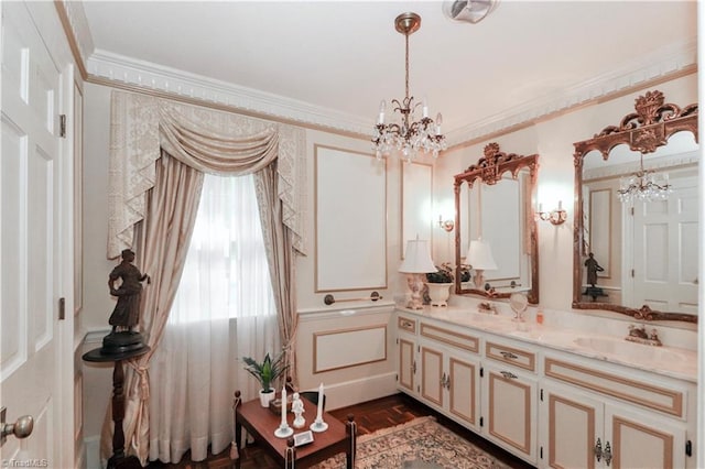 bathroom featuring a notable chandelier, crown molding, and double sink vanity