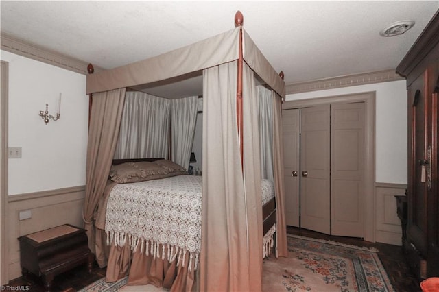 bedroom with a closet and wainscoting