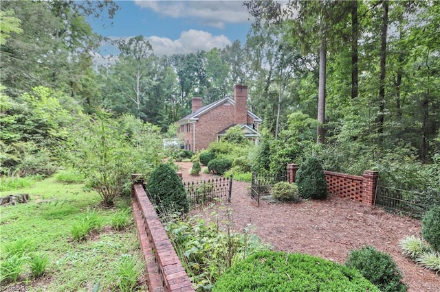 view of yard featuring fence and a view of trees