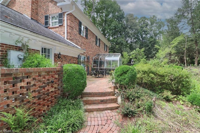 view of side of property with a patio area and brick siding