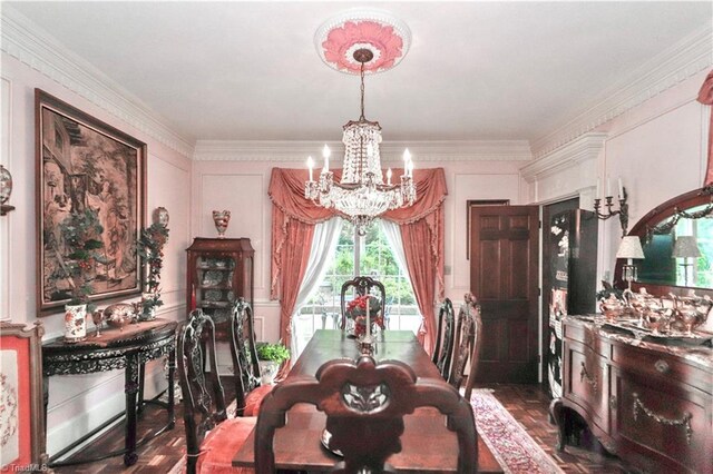 dining space with a chandelier, crown molding, and dark parquet floors